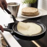 Lietiniai blynai prilipę prie keptuvės