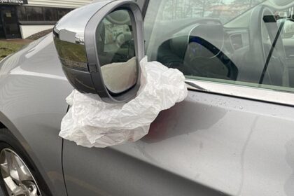Baltas audinio gabalas ant automobilio veidrodėlio
