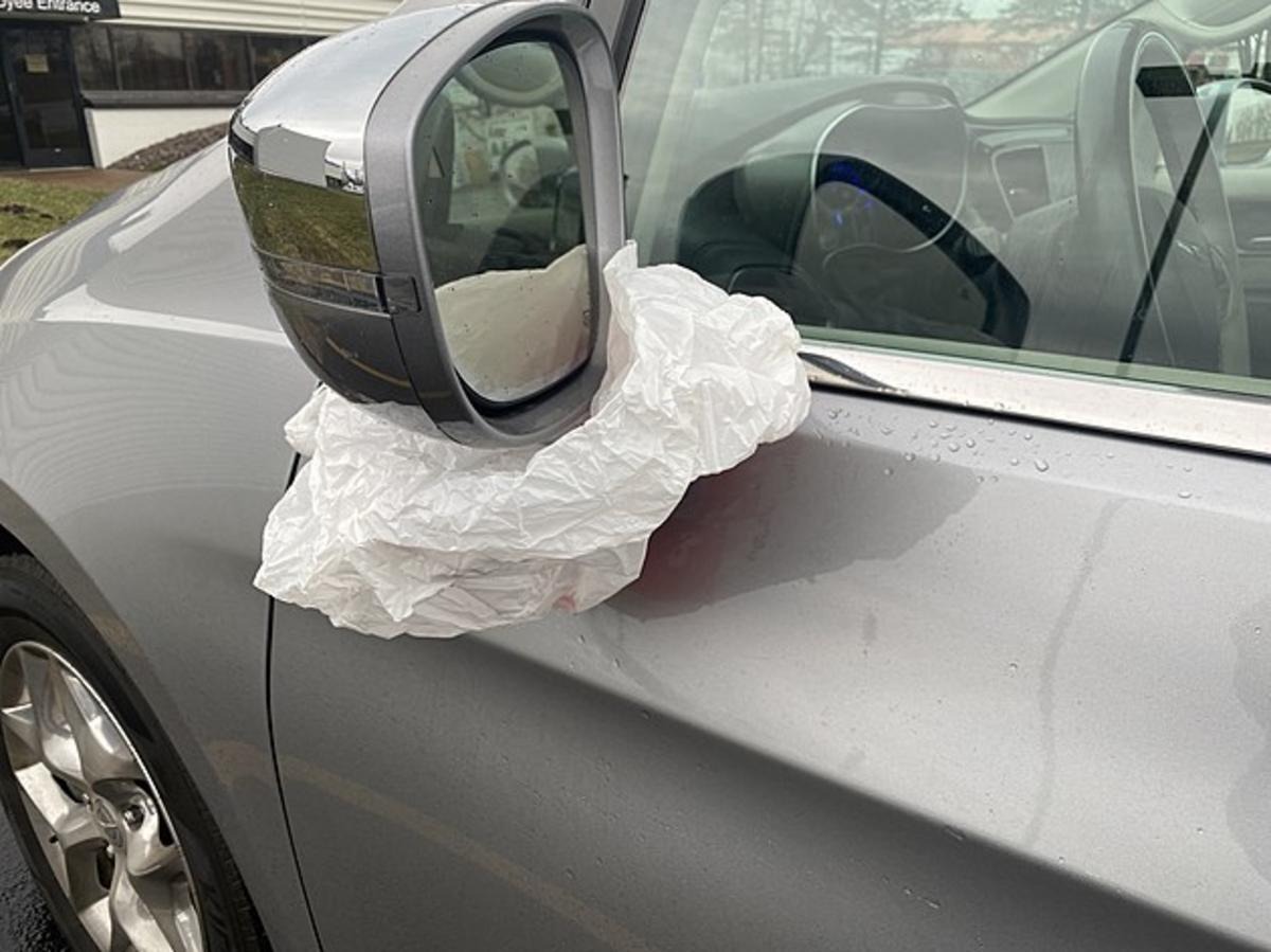 Baltas audinio gabalas ant automobilio veidrodėlio