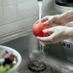 Obuolių plovimas po vandeniu
