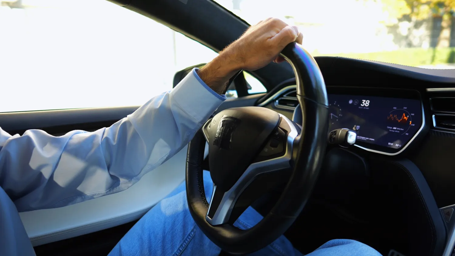 Žmogus vairuoja elektromobilį