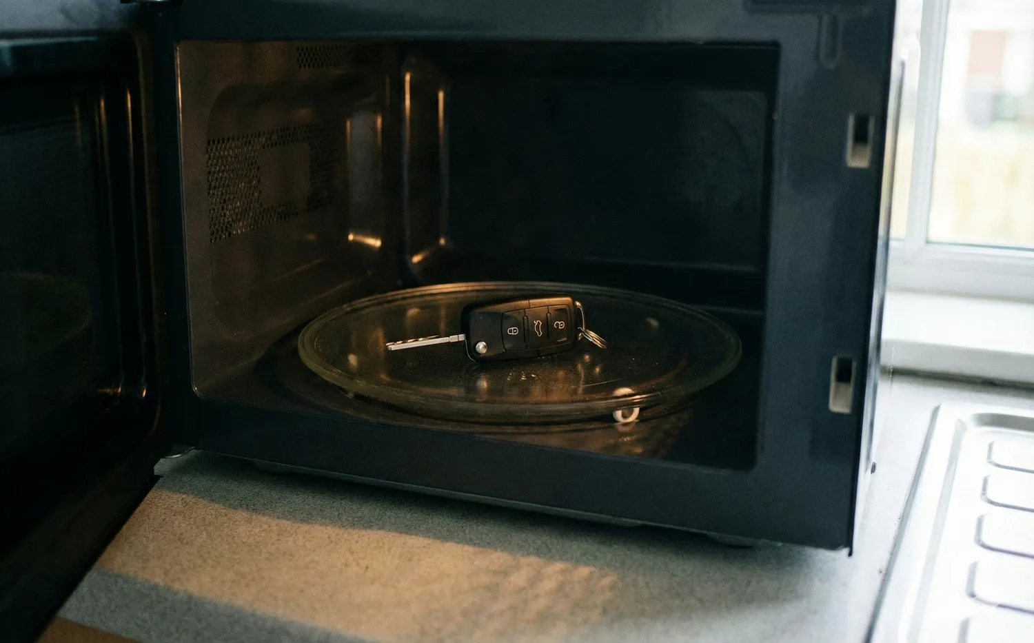 Automobilio raktas mikrobangų krosnelėje / AI nuotr.