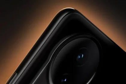 Išmaniojo telefono kamera su 100x priartinimu tamsiame fone, akcentuojant objektyvus ir šviečiančią detalę.